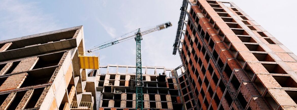 A crane is in the sky next to some buildings.