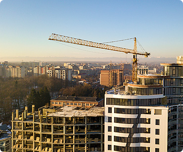 A crane is in the foreground of an urban setting.