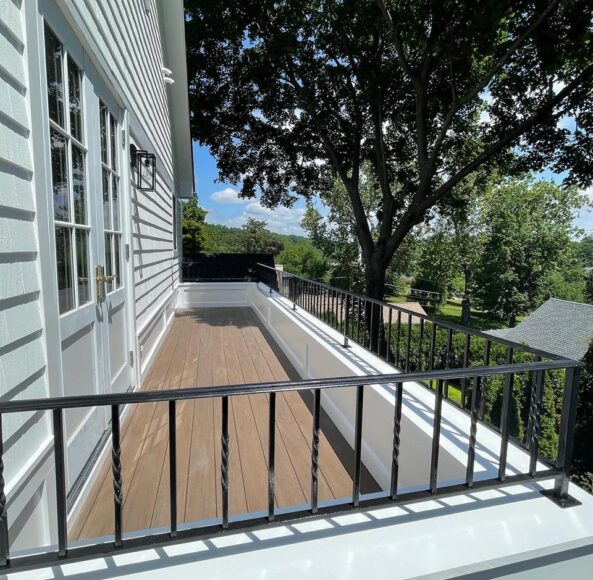 A balcony with a railing and a tree