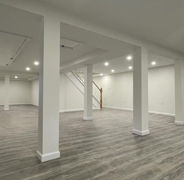 A large empty room with white walls and wooden floors.