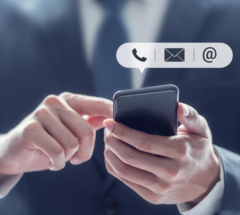 A man in suit holding a smart phone.